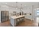 Spacious kitchen boasts a large island, white cabinetry, modern stainless-steel appliances, and hardwood floors at 4159 Millstream Rd, Denver, NC 28037