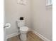 Cozy powder room featuring a white toilet, light gray walls, and wood-look tile flooring at 4159 Millstream Rd, Denver, NC 28037