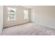 Comfortable bedroom with soft carpet, natural light from two windows, and a closet at 5735 Olive Beach Rd, Kannapolis, NC 28081