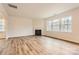 Bright living room featuring hardwood floors, a cozy fireplace, and large windows overlooking the backyard at 5735 Olive Beach Rd, Kannapolis, NC 28081