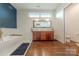 This modern bathroom offers wood cabinets, a soaking tub, and tile floors at 6017 Rose Valley Dr, Charlotte, NC 28210