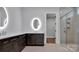 A modern bathroom featuring illuminated mirrors, a glass shower, and double vanity at 6055 Brush Crk, Monroe, NC 28110