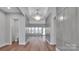 Hallway with hardwood flooring leading to a bright, window-filled living area at 6055 Brush Crk, Monroe, NC 28110