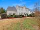 Inviting two-story home with classic design, green shutters, manicured shrubs and green lawn under a blue sky at 609 Sunset Point Dr, Rock Hill, SC 29732