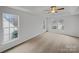 This main bedroom features a tray ceiling, carpet flooring, and large windows at 609 Sunset Point Dr, Rock Hill, SC 29732