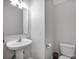Clean half bathroom featuring a modern pedestal sink and toilet at 662 Georgie St, Troutman, NC 28166