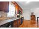 Well-lit kitchen with stainless steel sink, granite countertops, and dark wood cabinetry at 662 Georgie St, Troutman, NC 28166