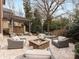 Inviting backyard with a stone patio, outdoor seating, and a fire pit surrounded by lush landscaping at 6711 Conservatory Ln, Charlotte, NC 28210