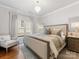 Stylish bedroom featuring a large upholstered bed, modern chandelier, and neutral color palette at 6711 Conservatory Ln, Charlotte, NC 28210