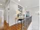Upstairs hallway with hardwood floors, decorative console table, and wrought iron railing at 6711 Conservatory Ln, Charlotte, NC 28210