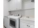 Functional laundry room with white cabinets, modern washer and dryer units, and a utility sink at 6711 Conservatory Ln, Charlotte, NC 28210