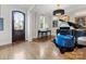 Bright living room with hardwood floors, piano, and an ornate chandelier fixture at 6711 Conservatory Ln, Charlotte, NC 28210
