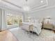 Bright main bedroom with a luxurious bed, chandelier, large windows, and hardwood flooring at 6711 Conservatory Ln, Charlotte, NC 28210