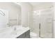 Bright bathroom has single vanity with gray cabinets, tile floors, walk-in shower with glass doors and a mirrored wall at 7535 Meridale Forest Dr # 107, Charlotte, NC 28269