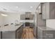 The modern kitchen has gray cabinets, a tiled backsplash, stainless appliances, granite counters and a spacious island at 7535 Meridale Forest Dr # 107, Charlotte, NC 28269