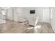 Cozy living room with light walls, wood floors, and a comfortable sitting area with two armchairs and a flat screen TV at 7535 Meridale Forest Dr # 107, Charlotte, NC 28269