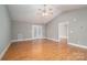 Spacious living room with vaulted ceiling, ceiling fan, and laminate floors leading to an adjacent room at 810 E Main St, Maiden, NC 28650