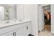 Bright bathroom featuring double sinks with white cabinets, a walk-in shower and a walk-in closet at 9203 Mackinaw Dr, Gastonia, NC 28056