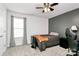 Bedroom with gray accent wall, neutral carpet, large window, and a ceiling fan at 9203 Mackinaw Dr, Gastonia, NC 28056