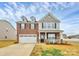 Inviting two-story home with a covered porch, brick facade, and attached two-car garage at 9203 Mackinaw Dr, Gastonia, NC 28056