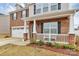 Charming two-story home with a brick facade, white porch, and attached two-car garage at 9203 Mackinaw Dr, Gastonia, NC 28056