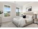 Sunlit bedroom with large windows offering outdoor views, complemented by a tufted headboard and tasteful decor at 111 Noah Ln, Troutman, NC 28166