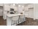 Modern kitchen with stainless steel appliances, a large island with seating, and sleek white cabinets, maximizing space and style at 111 Noah Ln, Troutman, NC 28166