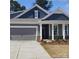 Charming single-Gathering home with a gray garage, gray siding, and a inviting front porch with brick accents at 113 Noah Ln, Troutman, NC 28166