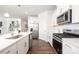 Modern kitchen featuring stainless steel appliances, white cabinets, and beautiful hardwood floors at 115 Noah Ln, Troutman, NC 28166