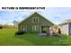 Home exterior featuring a large backyard with a stone firepit and Adirondack chairs at 117 Noah Ln, Troutman, NC 28166