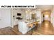 Modern kitchen featuring stainless steel appliances, a granite island, and bright cabinets at 117 Noah Ln, Troutman, NC 28166