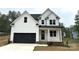 Charming new construction home featuring white siding, a black garage door, and a welcoming front porch at 157 Powder Spring Dr, Statesville, NC 28677