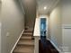 Staircase leads to a hallway with a view of a charming powder room featuring a pedestal sink at 157 Powder Spring Dr, Statesville, NC 28677