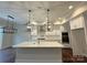Modern kitchen featuring white cabinets, an island with seating, and stainless steel appliances, seamlessly connected to the dining area at 157 Powder Spring Dr, Statesville, NC 28677
