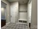 Mudroom features stylish patterned tile flooring, a built-in bench, and a storage closet at 157 Powder Spring Dr, Statesville, NC 28677