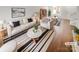 Bright, staged living room featuring modern furniture, a striped rug and wood floors at 16837 Greenlawn Hills Ct, Charlotte, NC 28213