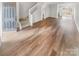Open-concept living room features wood laminate flooring, stairs and updated lighting at 16837 Greenlawn Hills Ct, Charlotte, NC 28213