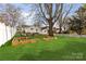 Lush backyard with green grass, garden beds, and comfortable seating area at 239 Euclid Ave, Statesville, NC 28677