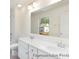 Bright bathroom featuring a double vanity, large mirror, and window providing natural light at 265 Red Fox Ln # 1P, China Grove, NC 28023