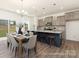Open-concept kitchen and dining area with island seating, stainless appliances, and backyard view at 265 Red Fox Ln # 1P, China Grove, NC 28023