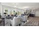 Open-concept living room flowing into a modern kitchen, featuring hardwood floors, large windows, and a stylish design at 265 Red Fox Ln # 1P, China Grove, NC 28023