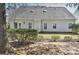 Back of home featuring vinyl siding, a gray roof, multiple windows, and nice landscaping at 3620 Cole Mill Rd, Charlotte, NC 28270