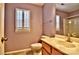 Bright bathroom with a single sink vanity, neutral tile floor, and plantation shutters at 3620 Cole Mill Rd, Charlotte, NC 28270