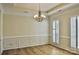 Elegant dining room featuring hardwood floors, crown molding, and a stylish chandelier at 3620 Cole Mill Rd, Charlotte, NC 28270
