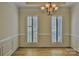 Elegant dining room featuring hardwood floors, crown molding, shutters and a stylish chandelier at 3620 Cole Mill Rd, Charlotte, NC 28270