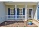 Cozy front porch with white columns, blue shutters, a storm door, and decorative planters at 3620 Cole Mill Rd, Charlotte, NC 28270