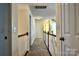Well-lit upstairs hallway featuring neutral paint, carpet, and classic wood railing at 3620 Cole Mill Rd, Charlotte, NC 28270