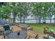 Lush backyard with mature trees, a wooden deck, and beautiful lake views at 405 Northwest Dr, Davidson, NC 28036