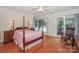 Spacious primary bedroom boasts hardwood floors, canopy bed, and lake views at 405 Northwest Dr, Davidson, NC 28036