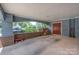 Open carport featuring brick accents, a red door, and space for parking and storage at 405 Northwest Dr, Davidson, NC 28036